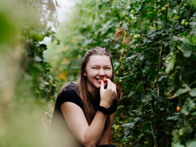 Bäuerin zwischen Tomatenpflanzen